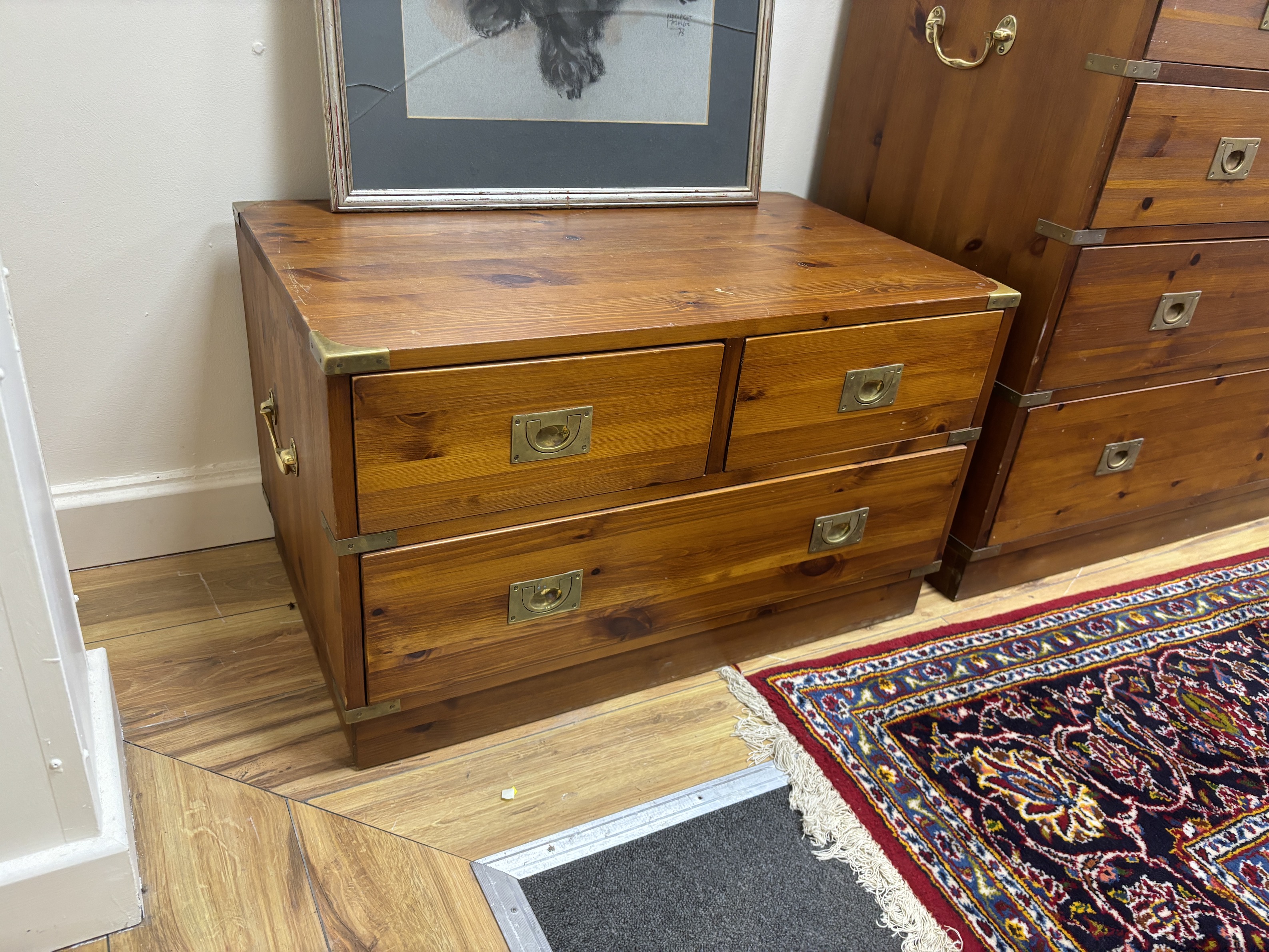 A pair of military style brass mounted pine three drawer low chests, width 77cm, depth 46cm, height 46cm